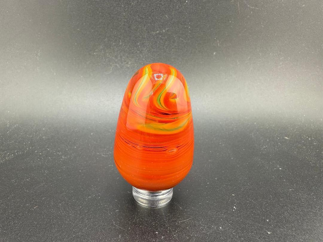 Handcrafted Paulson Pieces Easter Egg Marble in vibrant red and orange swirls, perfect for collectors.