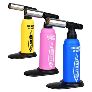 Colorful Blazer Big Shot GT 8000 torch lighters in yellow, pink, and blue on a black stand.