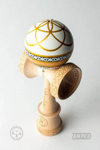 Sweets Kendama Johnny Raekes Amped model with a white and gold sphere on a natural wood base.