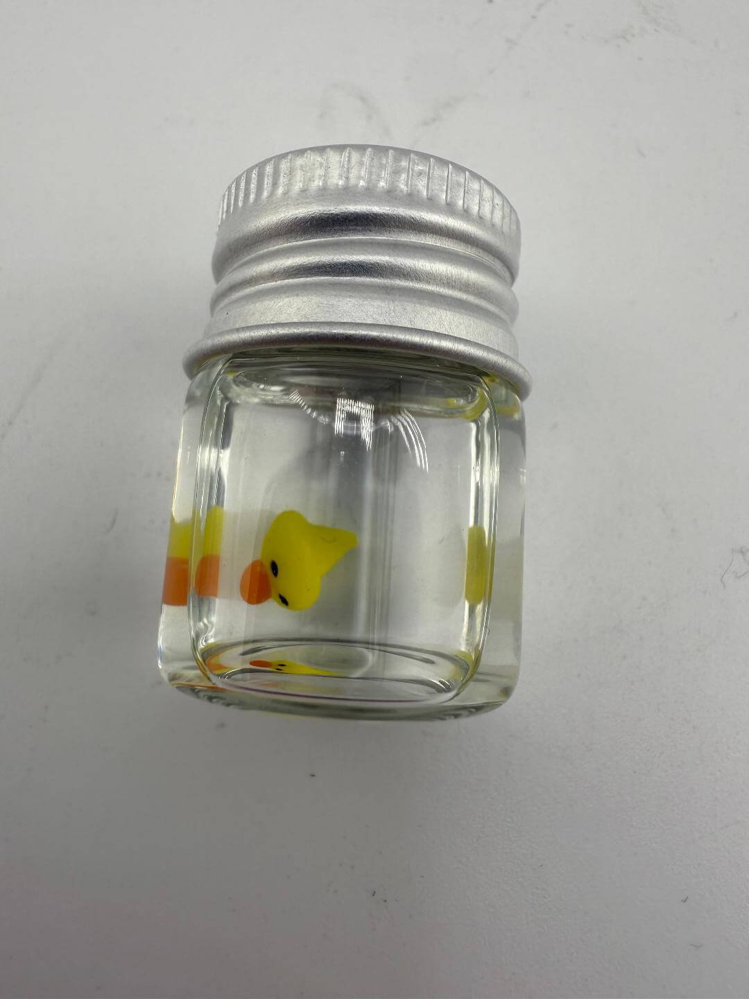 Lucky Gnome Glass Terp Pearl - Ducky in clear glass jar with silver lid, featuring a cute yellow duck design.