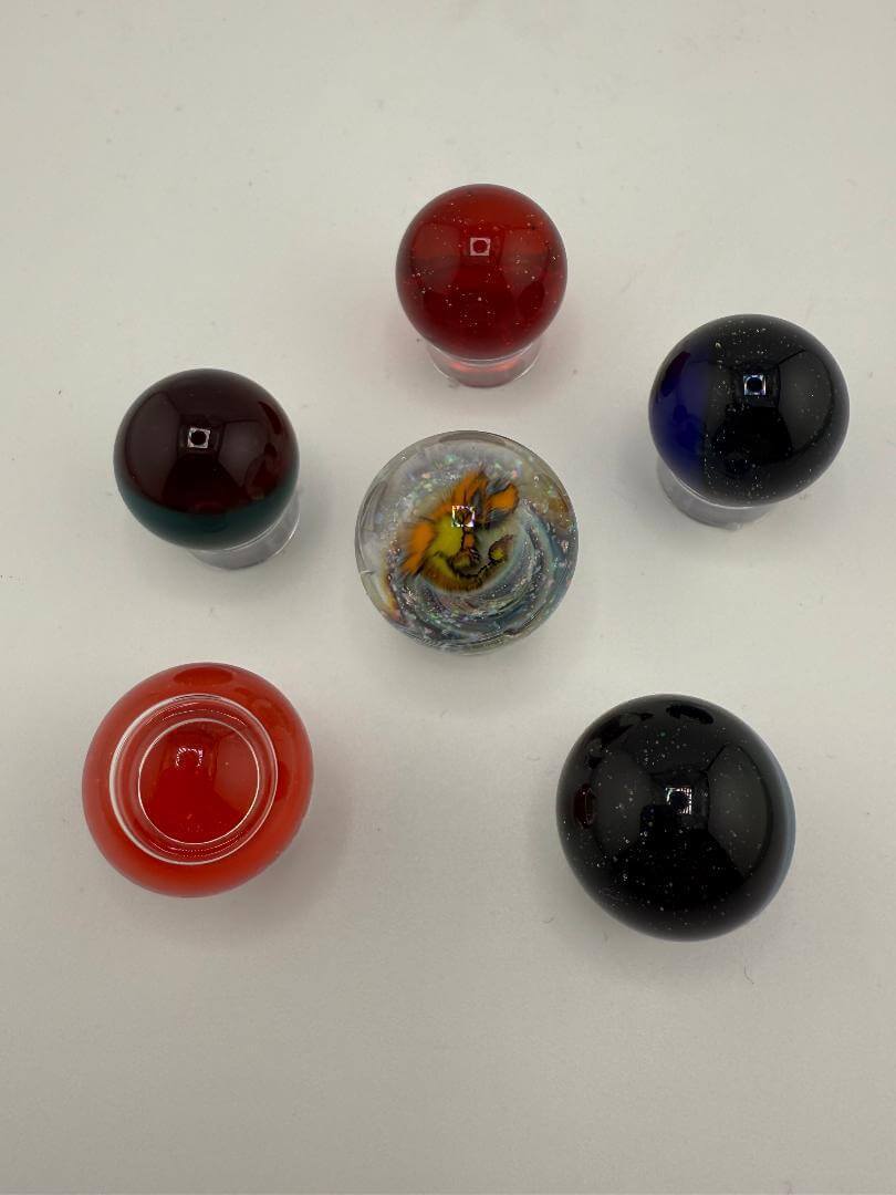 Colorful Paulson Pieces 20mm marble slurper tops arranged in a circle, showcasing vibrant designs and finishes.