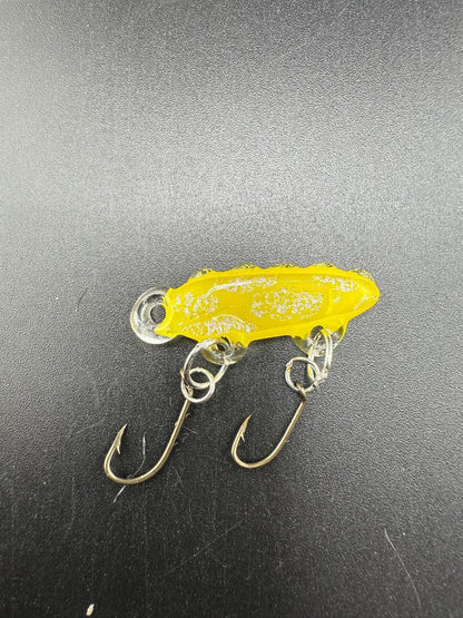 Handcrafted yellow glass fishing lure by Paulson Pieces, featuring unique design and durable hooks.