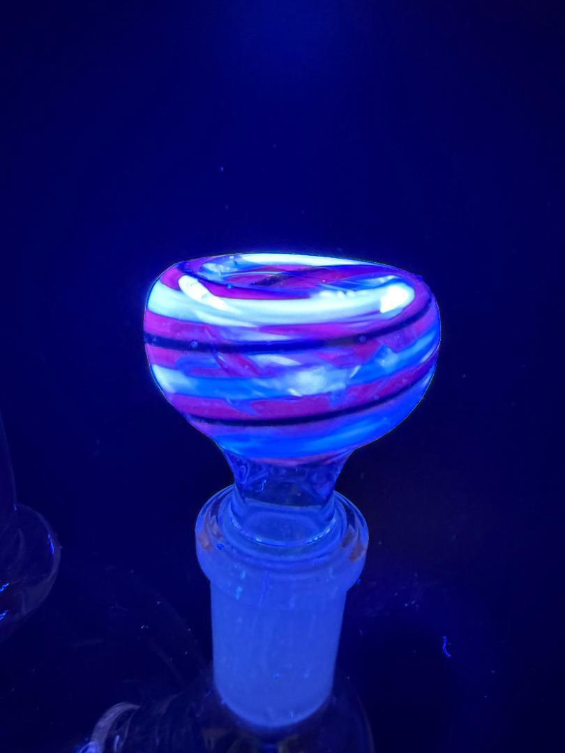 Filla John Black Light UV 14mm Bowl glowing under black light, featuring vibrant colors and a unique swirl design.