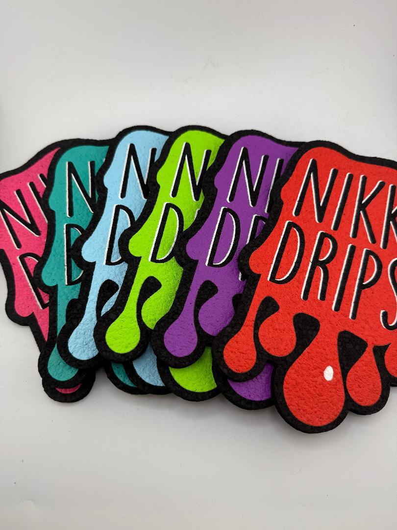 MoodMats x Nikk Drips colorful logo mats collection in various colors laid out together.