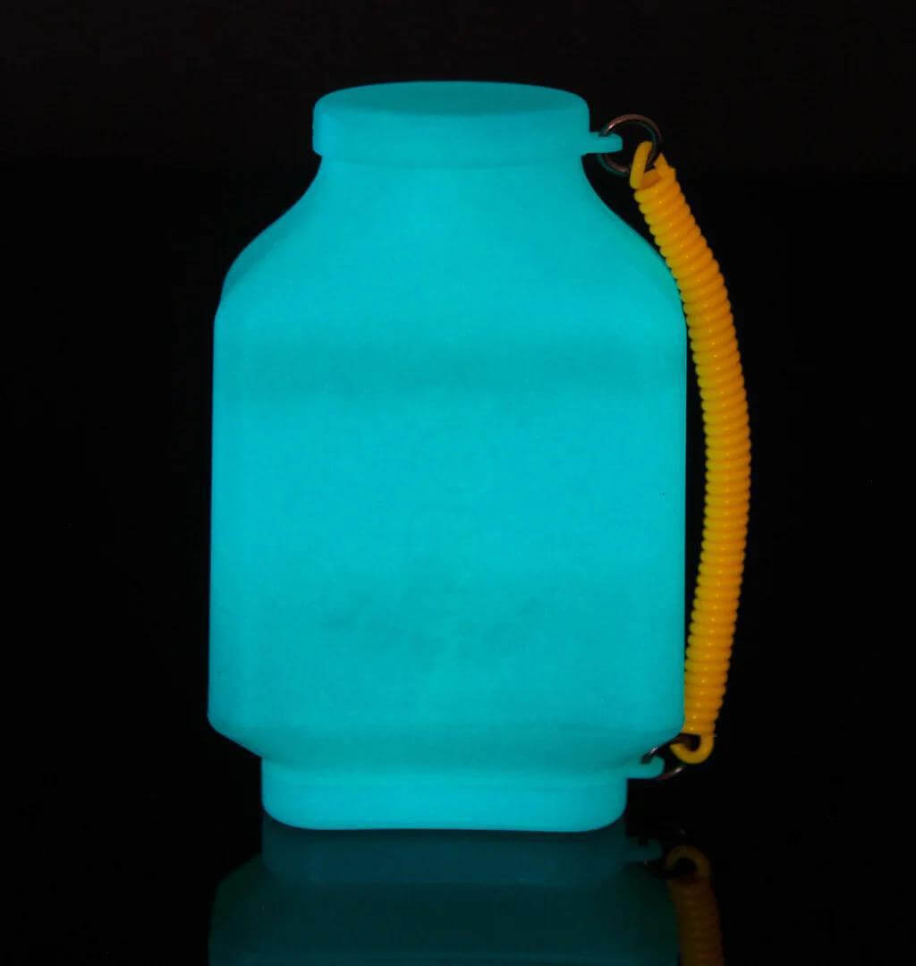 Smokebuddy Junior Personal Air Filter glowing in dark with a yellow travel cap attached.