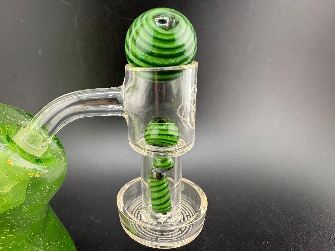 Green glass bong featuring striped terp pearls for enhanced heat distribution and style.