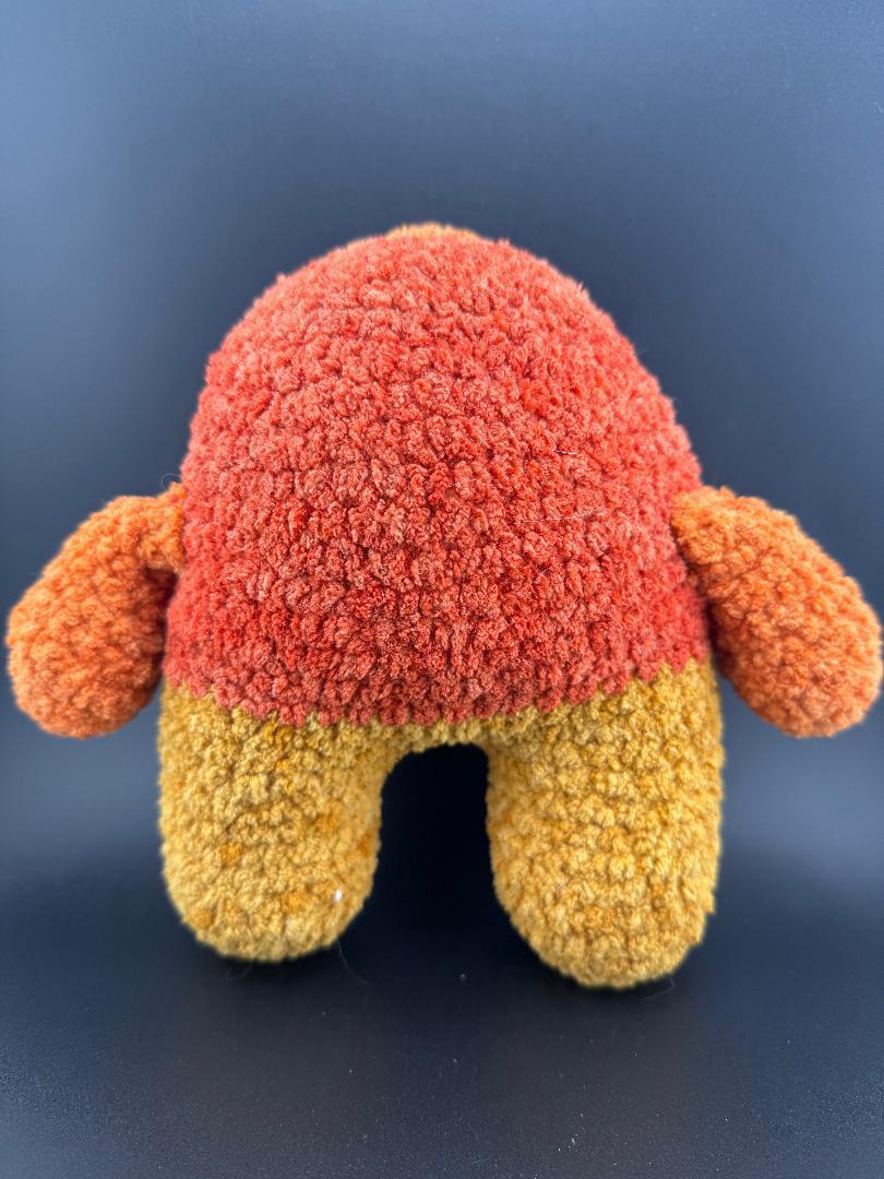 Crochet one-eyed monster plush in orange and yellow, perfect for kids and toy collectors.