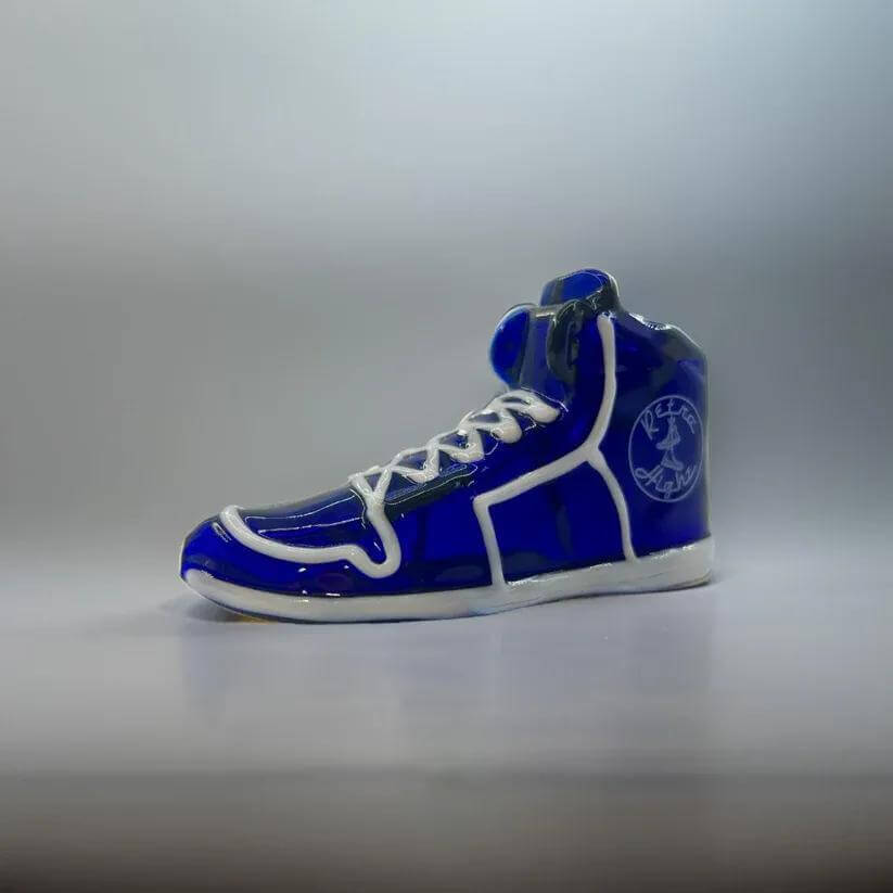 Blue high-top sneaker figurine with white accents, showcasing a stylish design.