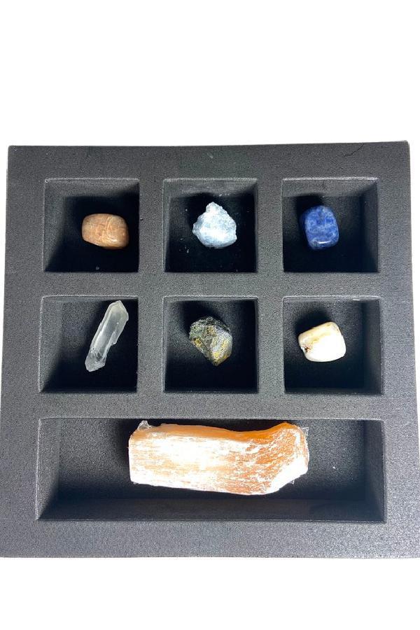 Geocentral Lunar Goddess advent calendar with seven moon-themed crystals in a black tray.