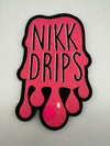 Nikk Drips logo patch with pink dripping effect and bold typography on a textured background.
