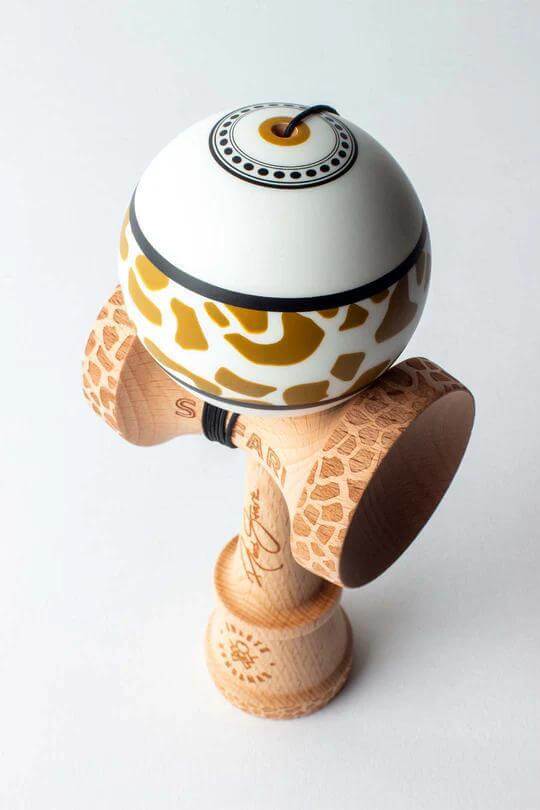 Sweets Kendama Reed Stark Gold Safari featuring a giraffe pattern design and natural wood base for ultimate play.