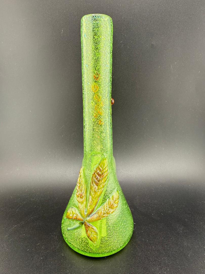 Green glass mini tube with pressed leaf design, showcasing vibrant dichroic effects, American-made craftsmanship.