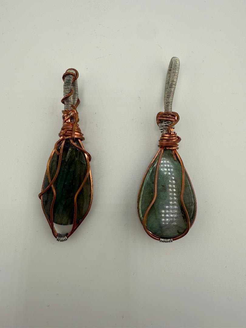 Two handcrafted wire-wrapped labradorite pendants showcasing natural beauty and unique artistry.