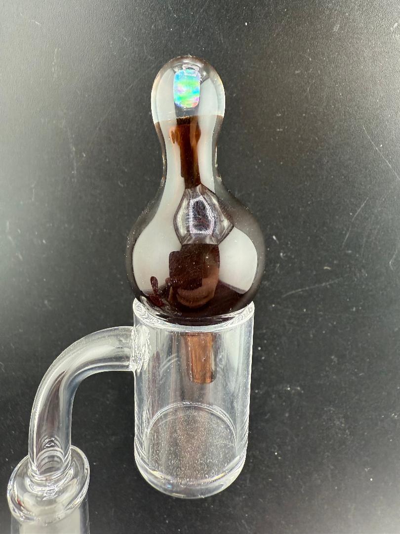 Windstar Glass Bubble Cap atop a clear quartz banger, designed for enhanced airflow and vaporization during dabbing.