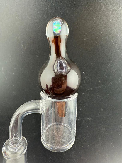 Windstar Glass Bubble Cap atop a clear quartz banger, designed for enhanced airflow and vaporization during dabbing.