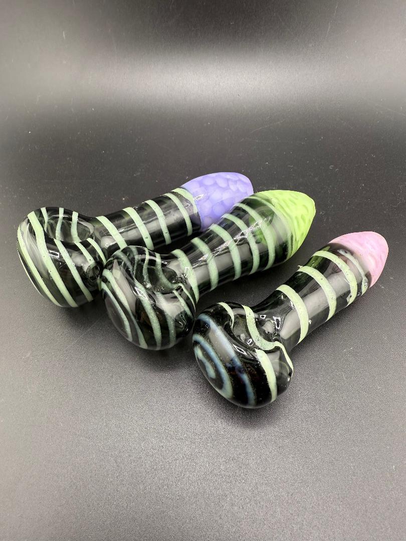 Colorful hand pipes in black with slime-green, purple, and pink accents on a dark background.