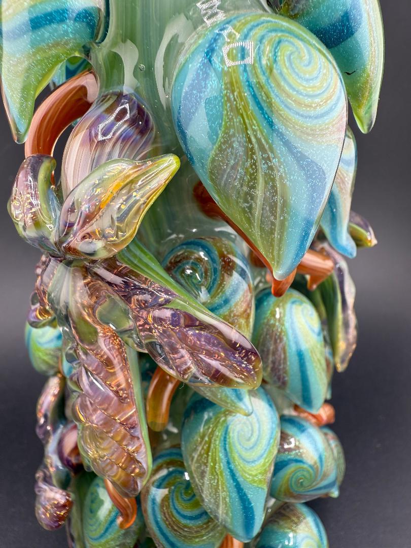 Close-up of Mr. Gray Glass Dichroic Leaf Nug Tube with vibrant, swirling blue and green leaf design.