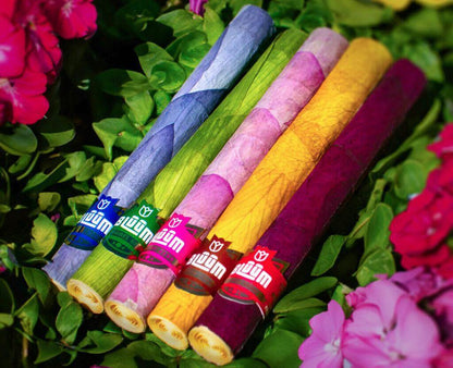 Bluum Cones in five vibrant colors crafted from rose and lotus leaves, surrounded by colorful flowers.