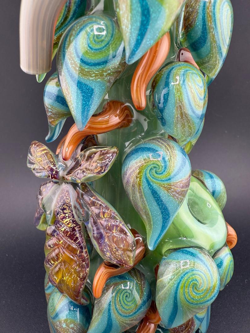 Close-up of Mr. Gray Glass Dichroic Leaf Nug Tube showcasing vibrant blue and green leaf designs and intricate details.