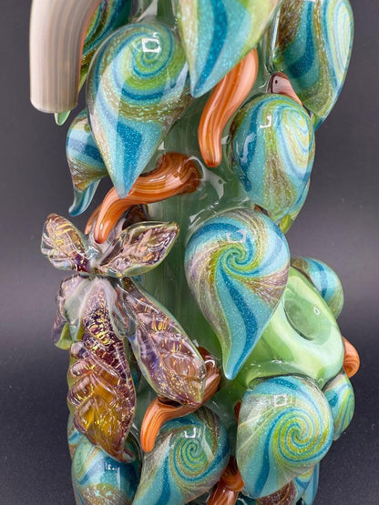 Close-up of Mr. Gray Glass Dichroic Leaf Nug Tube showcasing vibrant blue and green leaf designs and intricate details.