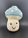 Crochet mushroom plushy with a smile, blue cap and white spots, perfect for kids and collectors.