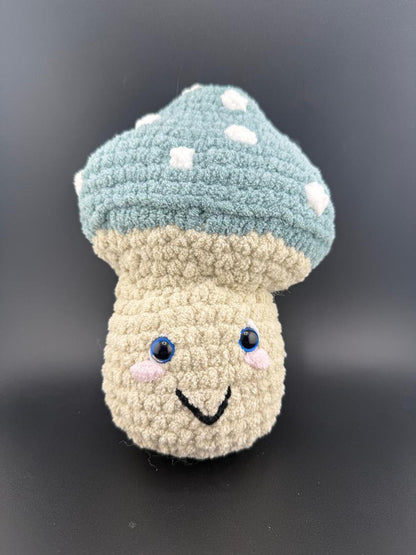 Crochet mushroom plushy with a smile, blue cap and white spots, perfect for kids and collectors.