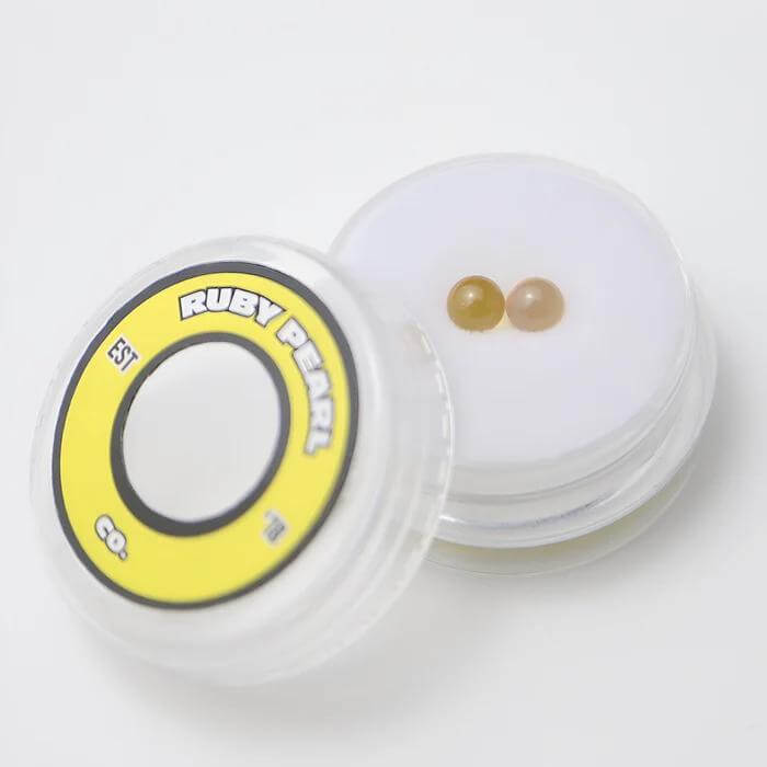 Ruby Pearl Co Yellow Sapphire Terp Pearls in clear container for enhanced dabbing experience and vapor production.