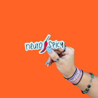 A hand holding a BBB Sticker | Neuro Spicy on an orange background.