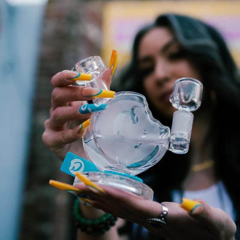 Stylish Cookie Bite Bubbler held by a woman, showcasing unique design and durable borosilicate glass.