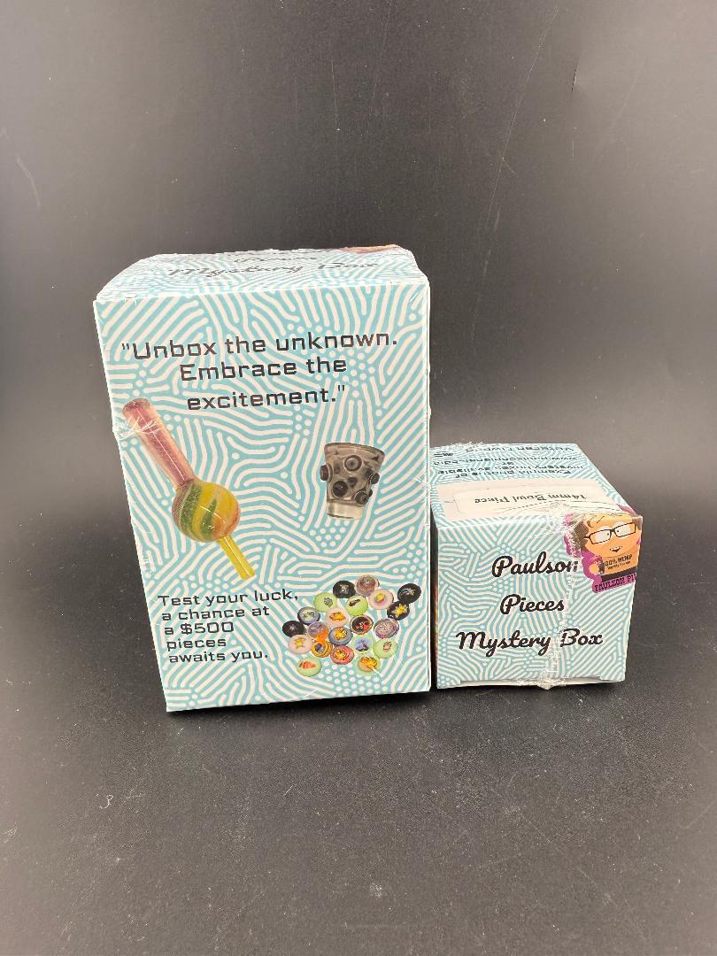 Paulson Pieces Mystery Box - Puffco Mini Bubble Cap packaging with vibrant designs and text promoting unboxing excitement.
