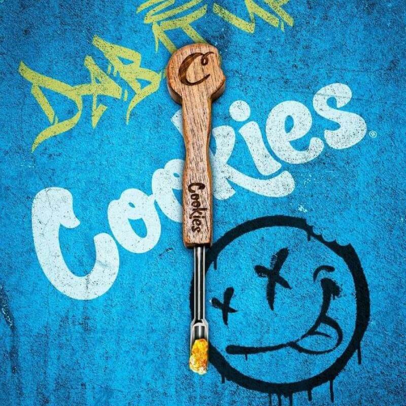 Cookies Wax Dab Tool with wooden handle on a vibrant blue background, perfect for dabbing concentrates.