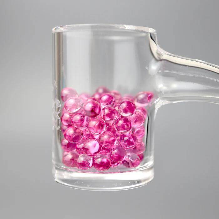 Ruby Pearl Co Pink Sapphire Terp Pearls in a dab rig for optimized dabbing and flavor enhancement.