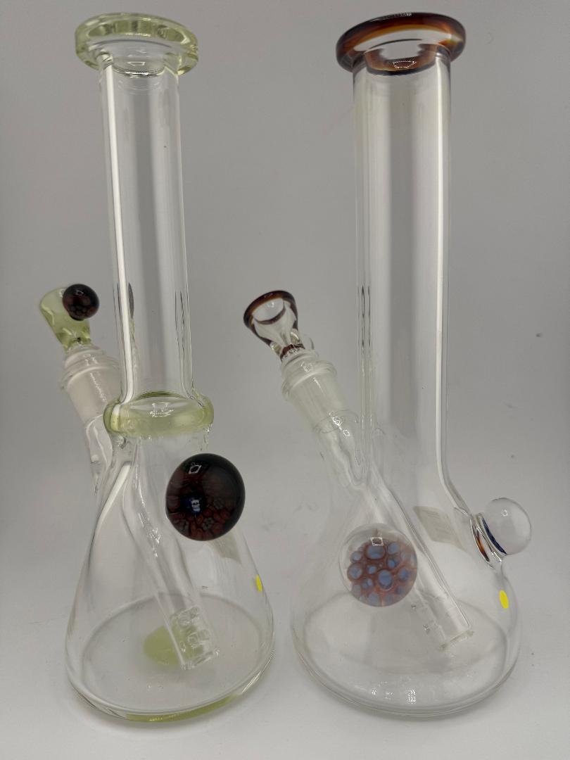 Two handcrafted glass bongs in medium beaker shape with unique color accents and clear design, perfect for style and function.