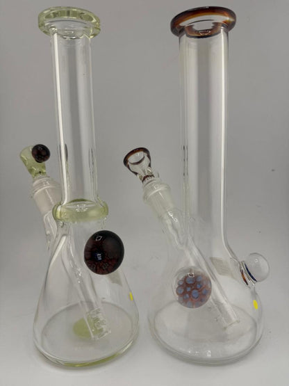 Two handcrafted glass bongs in medium beaker shape with unique color accents and clear design, perfect for style and function.