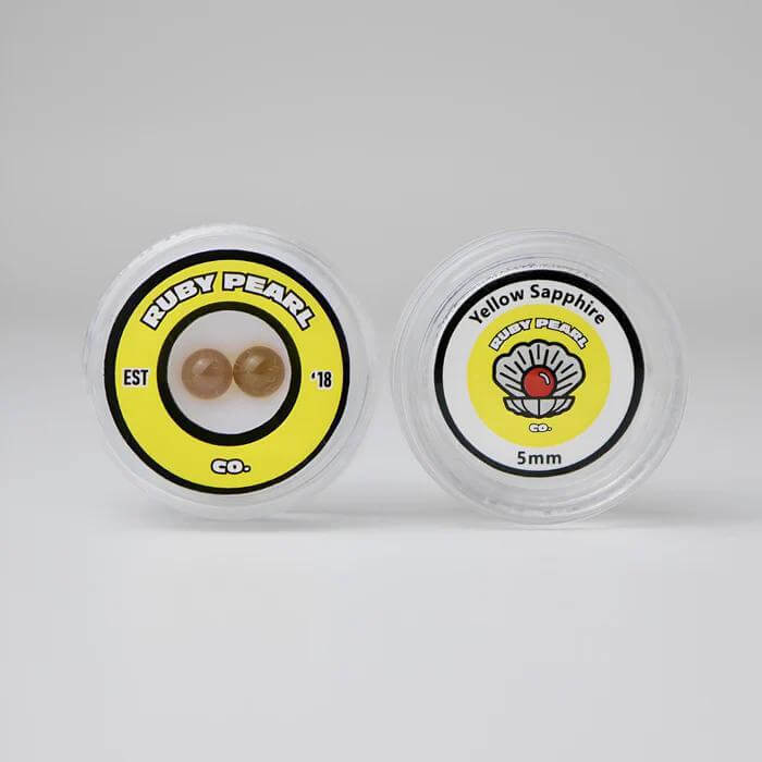 Ruby Pearl Co Yellow Sapphire Terp Pearls in clear container, featuring premium lab-grown yellow sapphire for dabbing.