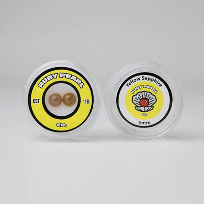 Ruby Pearl Co Yellow Sapphire Terp Pearls in clear container, featuring premium lab-grown yellow sapphire for dabbing.