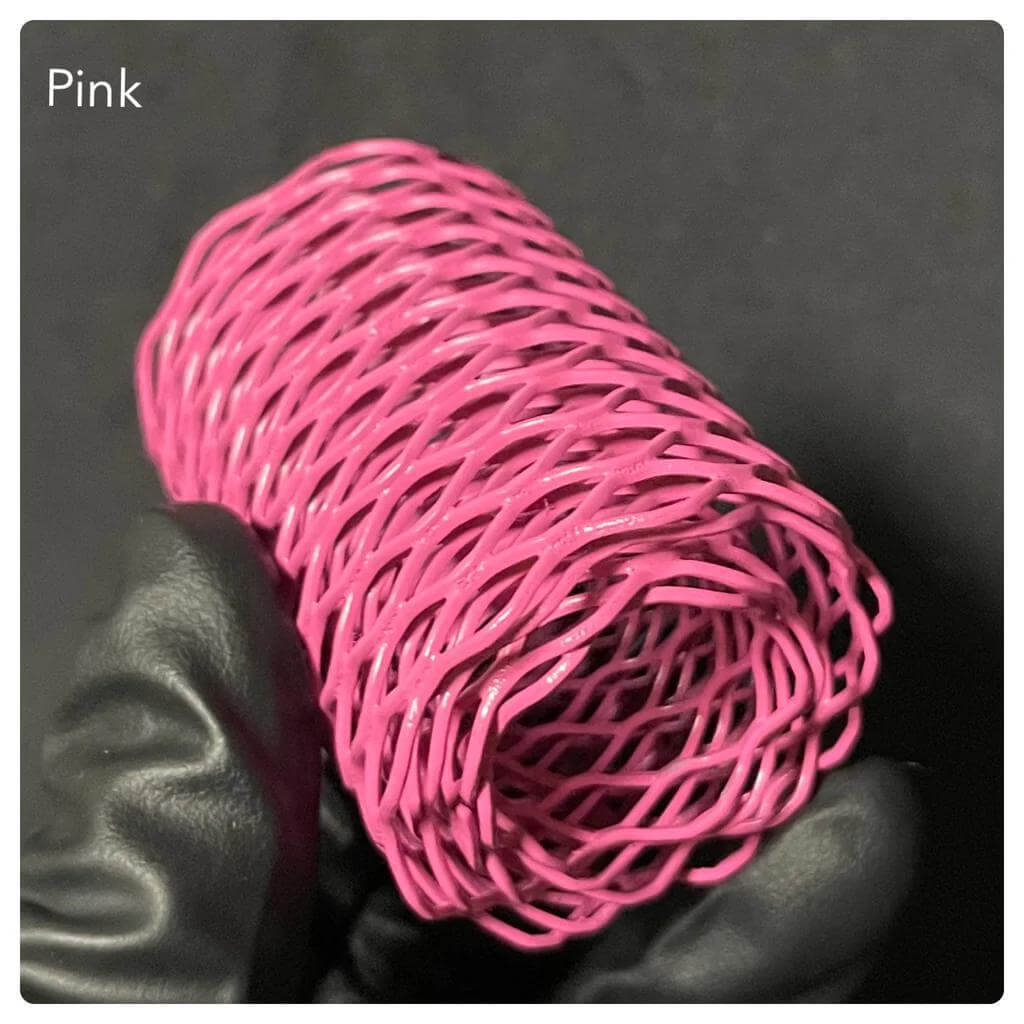 Pink wire mesh coil held in a gloved hand, ideal for crafts and creative projects.