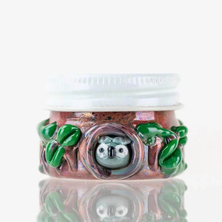 Empire Glassworks Terp Jar with owl design, ideal for storing terpenes and concentrates, featuring decorative green leaves.