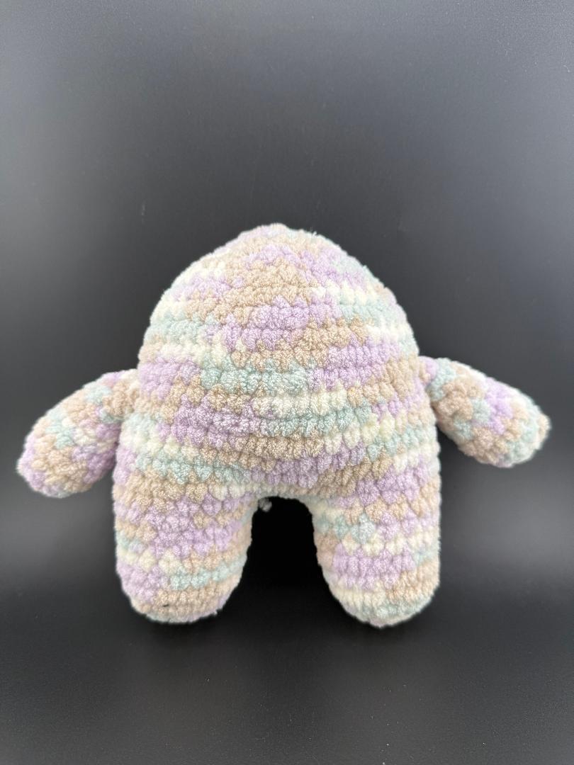 Colorful crochet one-eyed monster plush toy with a soft texture and unique pastel pattern.