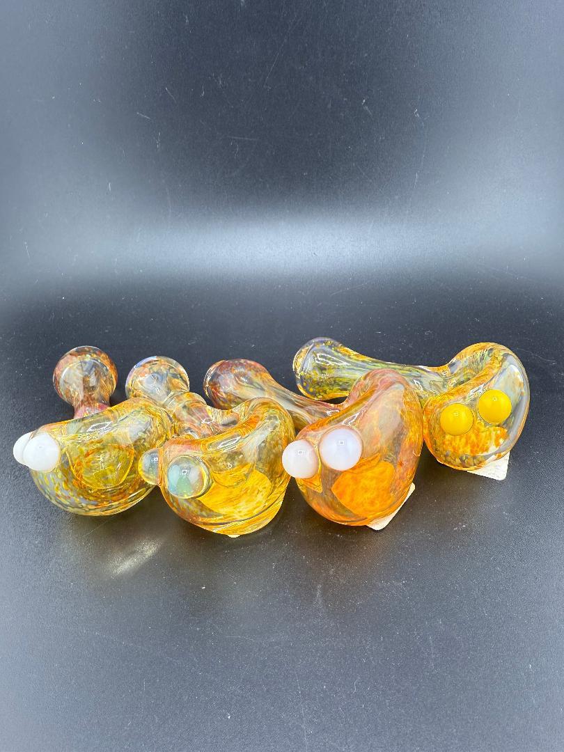 Handcrafted glass pipes in vibrant colors, featuring unique designs, perfect for smoking enthusiasts.