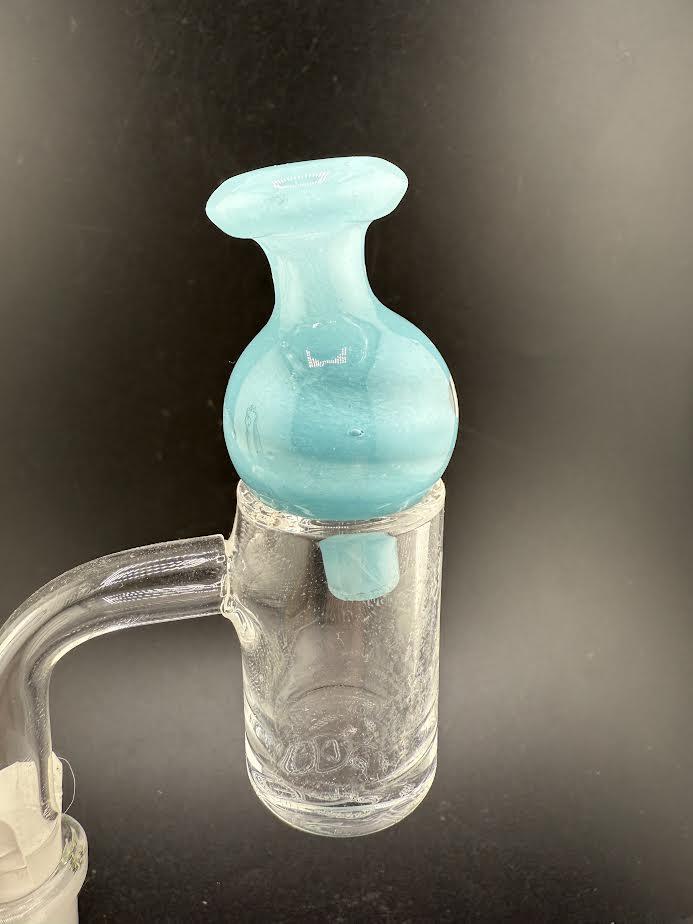 Close-up of a bolt up bubble cap, featuring a blue glass design, fitted to a glass banger.