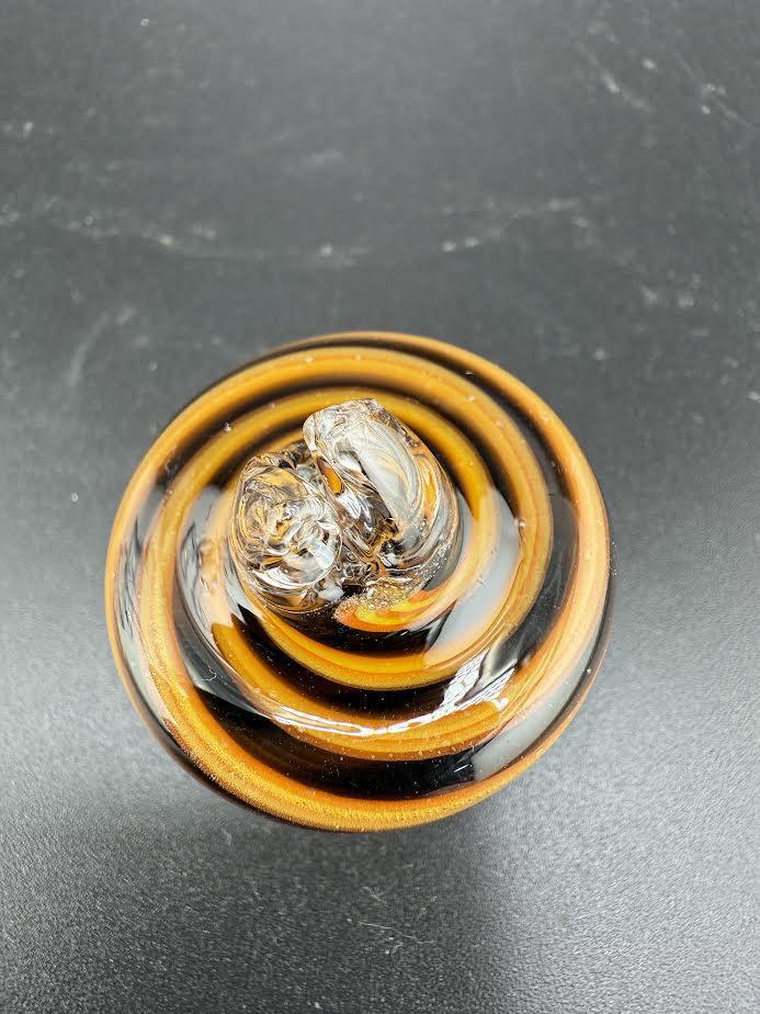 Black and orange spinner cap with spiral design, perfect for collectors and enthusiasts.