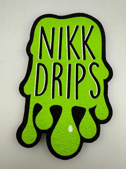 Nikk Drips logo mat in bright green color with dripping design, made from recycled materials.