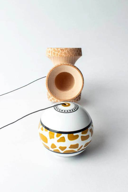 Sweets Kendama Reed Stark Gold Safari with unique giraffe print design, showcasing the kendama ball and cup.