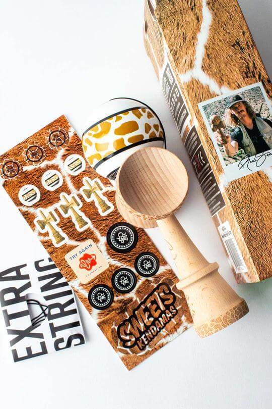 Sweets Kendama Reed Stark Gold Safari with stickers, extra string, and box, showcasing unique design and branding.