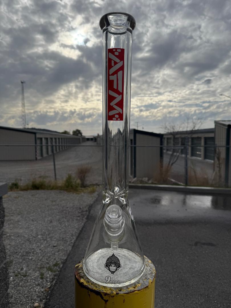 AFM Glass "18 Clear Beaker Flower Piece Red AFM Logo 14mm 45° displayed outdoors with cloudy sky background.