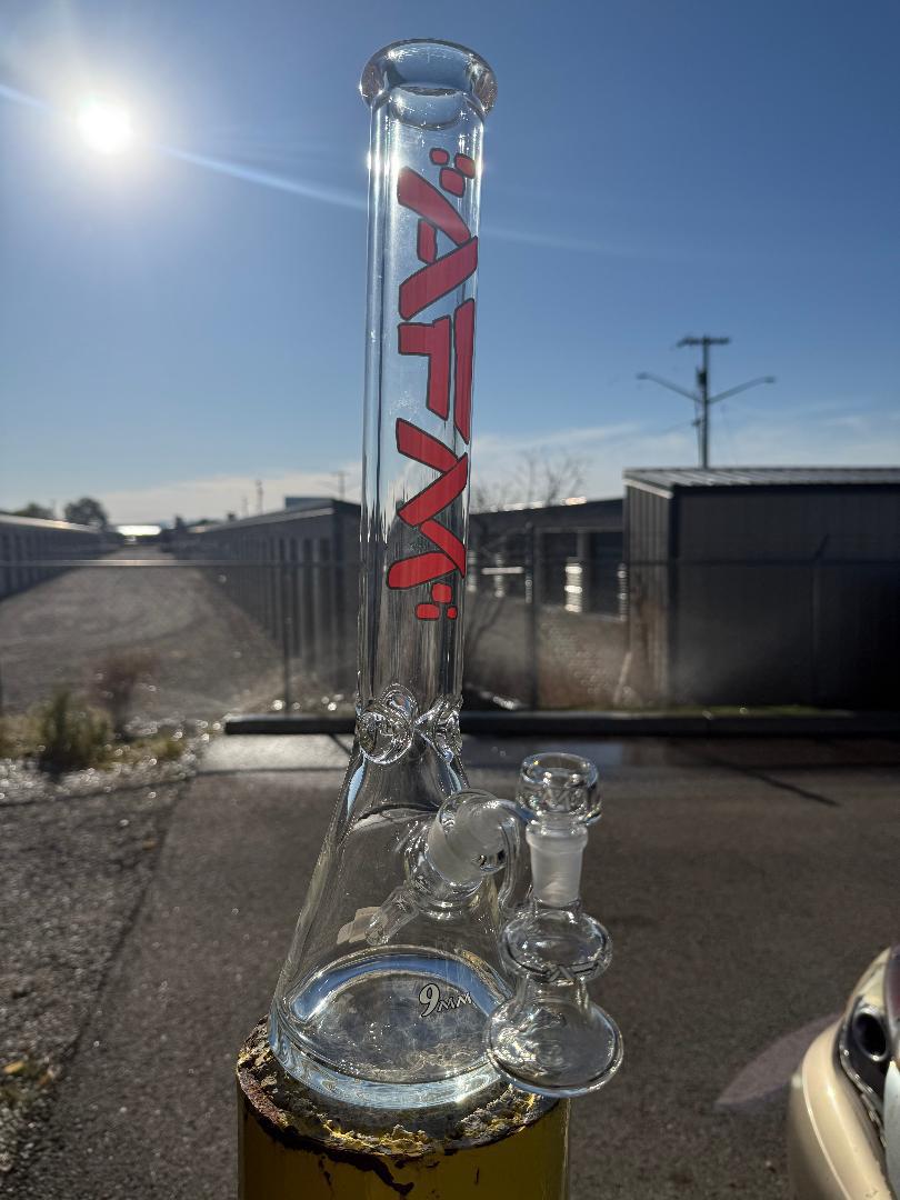 AFM Glass 18" Beaker w/ Ashcatcher 14mm 45° on display in sunlight, showcasing its sleek design.