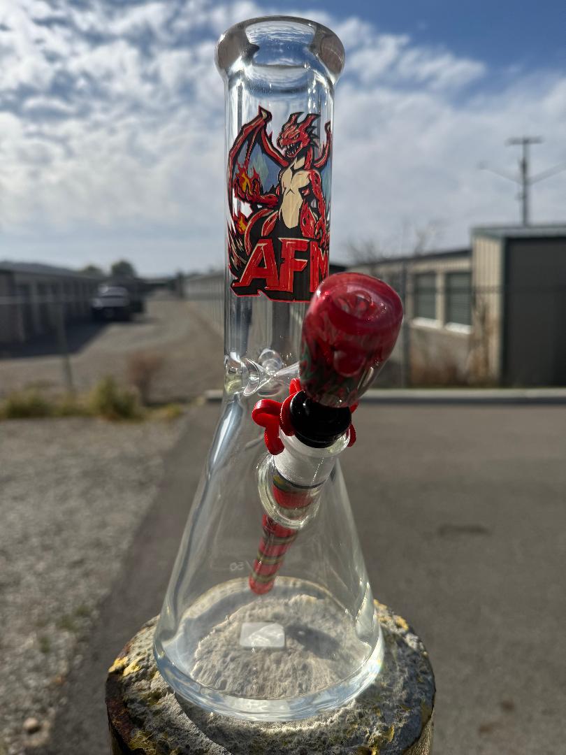 AFM Glass Flame Dragon Beaker 12" 9mm Thick 14mm 45° displayed outdoors against a scenic background.