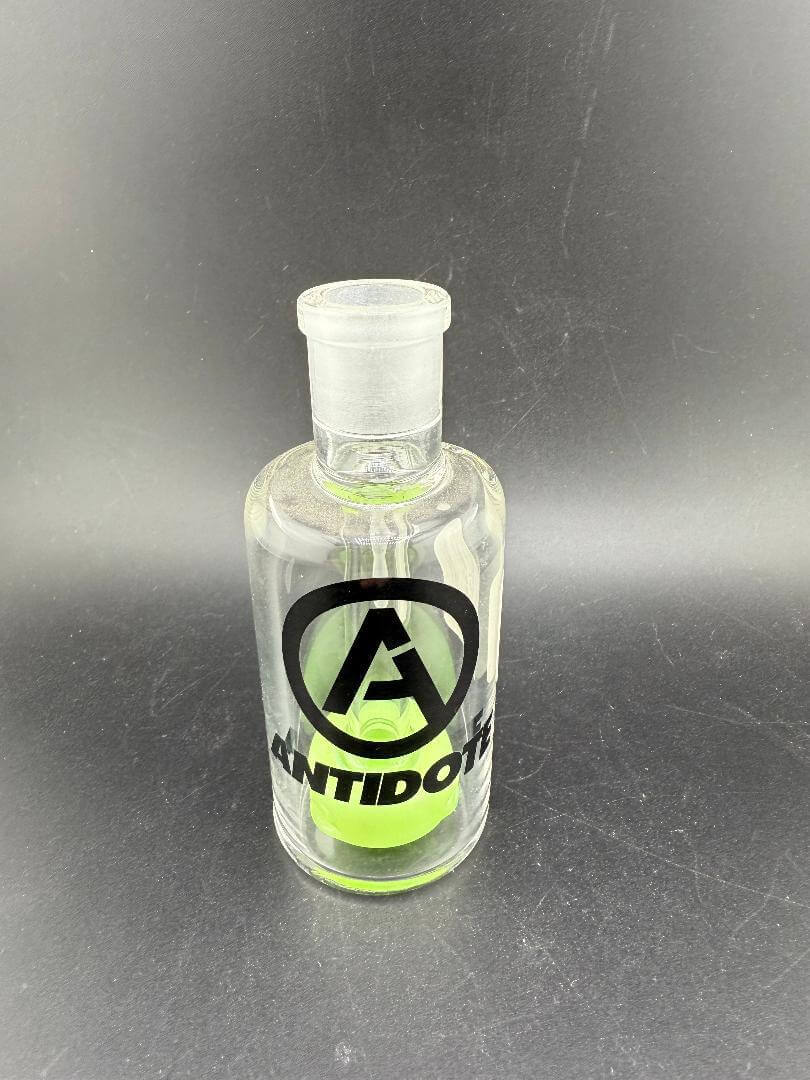 Antidote Glass 14mm 90° Color Ash Catcher with green accents and logo on borosilicate glass.