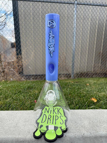 Antidote Glass Big Base Beaker Blue 14mm 45° displayed outdoors on a concrete surface with a grass background.